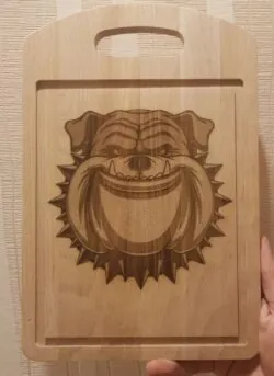 the cutting board engraved the face of a sloppy dog